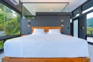 Modern bedroom with panoramic ocean views and glass walls in Costa Rica.