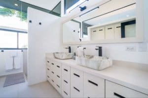 Modern bathroom with double stone sinks and large mirror in Dominical.