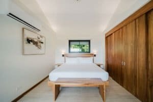 Contemporary bedroom with wooden closet and minimalist decor.