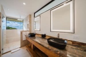 Modern bathroom with dual sinks and ocean view window in Costa Rica estate.