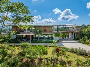 Modern luxury estate in Dominical with lush gardens and mountain backdrop.