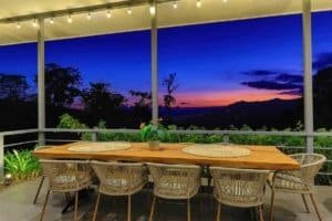 Beautiful mountain sunset view from a screened porch with dining table.