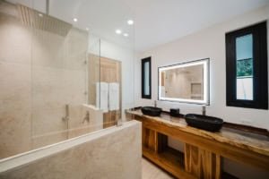 Modern bathroom with dual black vessel sinks and large mirror.