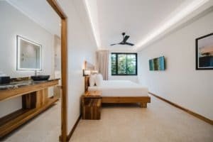 Modern bedroom with ocean view, minimalist decor, and large window in Costa Rica.