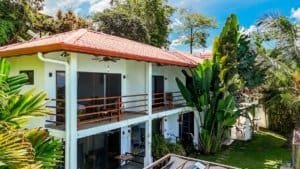 Beautiful Costa Rican home with ocean view, lush greenery, and spacious balcony.