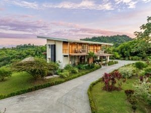 Modern Costa Rica estate with infinity pool and mountain backdrop at sunset.