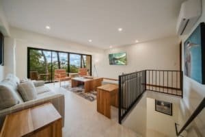 Spacious living room with large windows overlooking jungle and ocean views.
