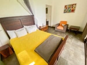 Comfortable bedroom with yellow bedding and ocean view artwork.
