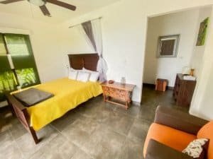 Bedroom with yellow bedspread, ocean view, and modern decor in Dominical.