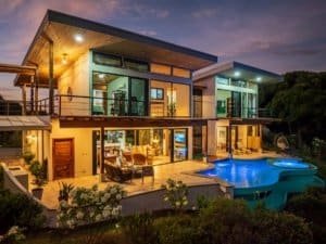 Modern Costa Rica estate with infinity pool and mountain backdrop at sunset.