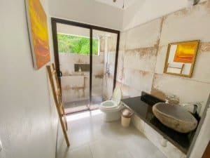 Bathroom with stone sink, modern decor, and ocean view in Dominical.