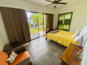 Bedroom with ocean view, sliding glass door, and tropical scenery in Dominical.