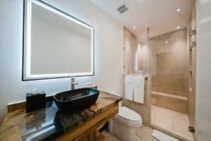 Contemporary bathroom with walk-in shower, black vessel sink, and large mirror.