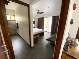 Bedroom with ocean view, large windows, and modern decor in Dominical.