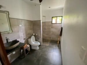 Bathroom with shower, toilet, and sink in a modern Costa Rican home.