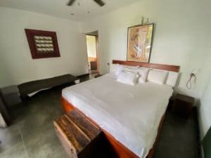 Comfortable bedroom with white bedding and artwork in Dominical estate.