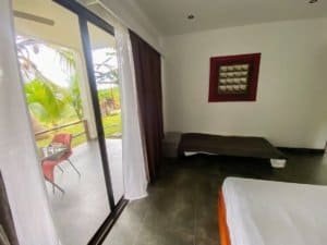Bedroom with sliding glass door leading to balcony and ocean view.
