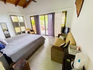 Bedroom with balcony and ocean view, modern decor, and natural light.