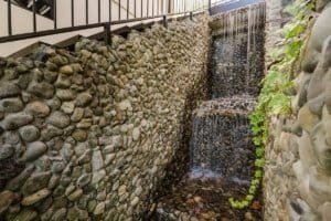Stone wall with waterfall feature in Costa Rican luxury estate.