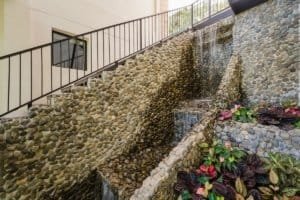 Stone water feature with plants in a Costa Rican estate garden.