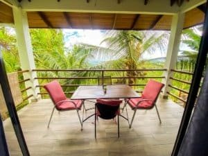 Balcony with table and chairs overlooking lush tropical jungle in Dominical.