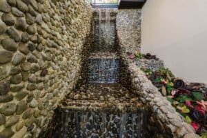 Stone water feature with cascading waterfalls in Dominical luxury estate.