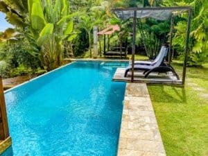 Luxury pool with lounge chairs and lush tropical garden in Dominical.