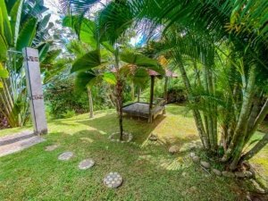 Lush tropical garden with gazebo and palm trees in Dominical, Costa Rica.