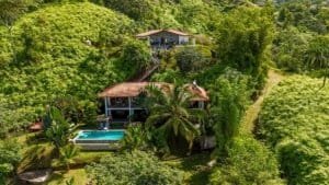 Beautiful Costa Rican home with ocean view, pool, and lush greenery.