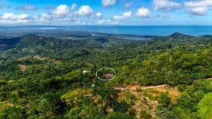 Aerial view of lush green hills and ocean in Dominical, Costa Rica.