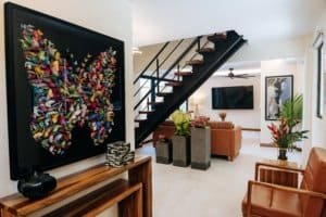 Elegant living room with staircase, artwork, and tropical plants in Costa Rica.
