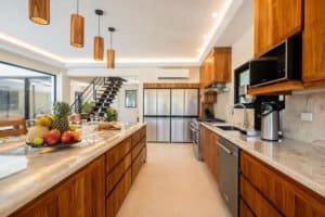 Modern kitchen with wooden cabinets, island, and mountain view in Dominical.