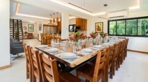 Elegant dining area with wooden furniture and rainforest view in Dominical.