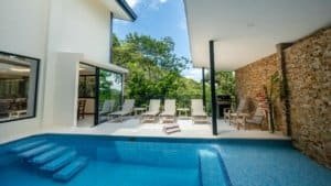 Modern pool with mountain and rainforest views in Dominical estate.