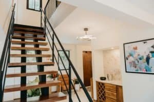 Contemporary home interior featuring wooden staircase and artwork.