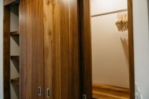 Elegant wooden closet with sliding doors and a walk-in area in a luxury estate.