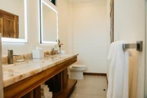 Elegant bathroom with wooden vanity, large mirror, and white towels.