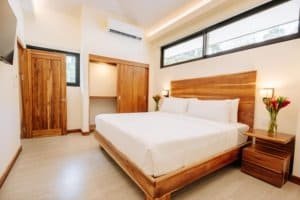 Modern bedroom with wooden furniture and rainforest view in Costa Rica.