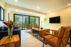 Spacious living room with large windows, modern furniture, and mountain view.