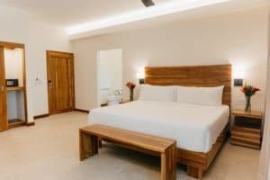 Modern bedroom with wooden furniture and rainforest view in Costa Rica.
