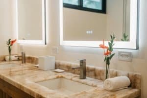 Modern bathroom with marble countertop, sink, and mountain view windows.