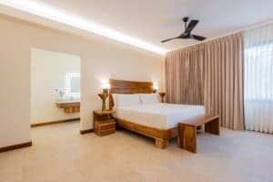 Spacious bedroom with modern decor and rainforest view in Costa Rica.