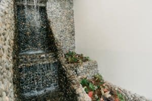 Stone water fountain with lush plants in Dominical estate near Marina Pez Vela.