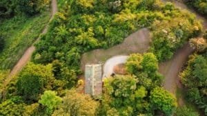 Aerial view of lush green trees and a small building in Costa Rica.