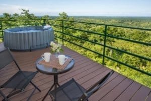Balcony with hot tub and seating overlooking lush green landscape in Dominical.