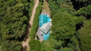 Aerial view of a house with saltwater pool surrounded by lush greenery in Dominical.