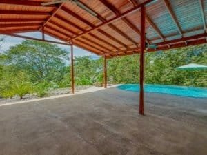 Outdoor covered patio with pool and lush greenery in Dominical, Costa Rica.