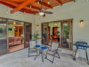 Covered patio with ceiling fan, outdoor dining, and BBQ in Dominical area.