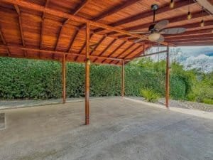 Spacious covered outdoor patio with ceiling fan and lush greenery in Costa Rica.