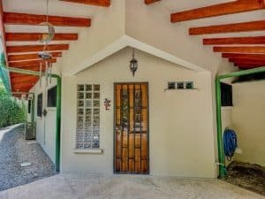 Charming entrance of a Costa Rican home with wooden door and glass block window.